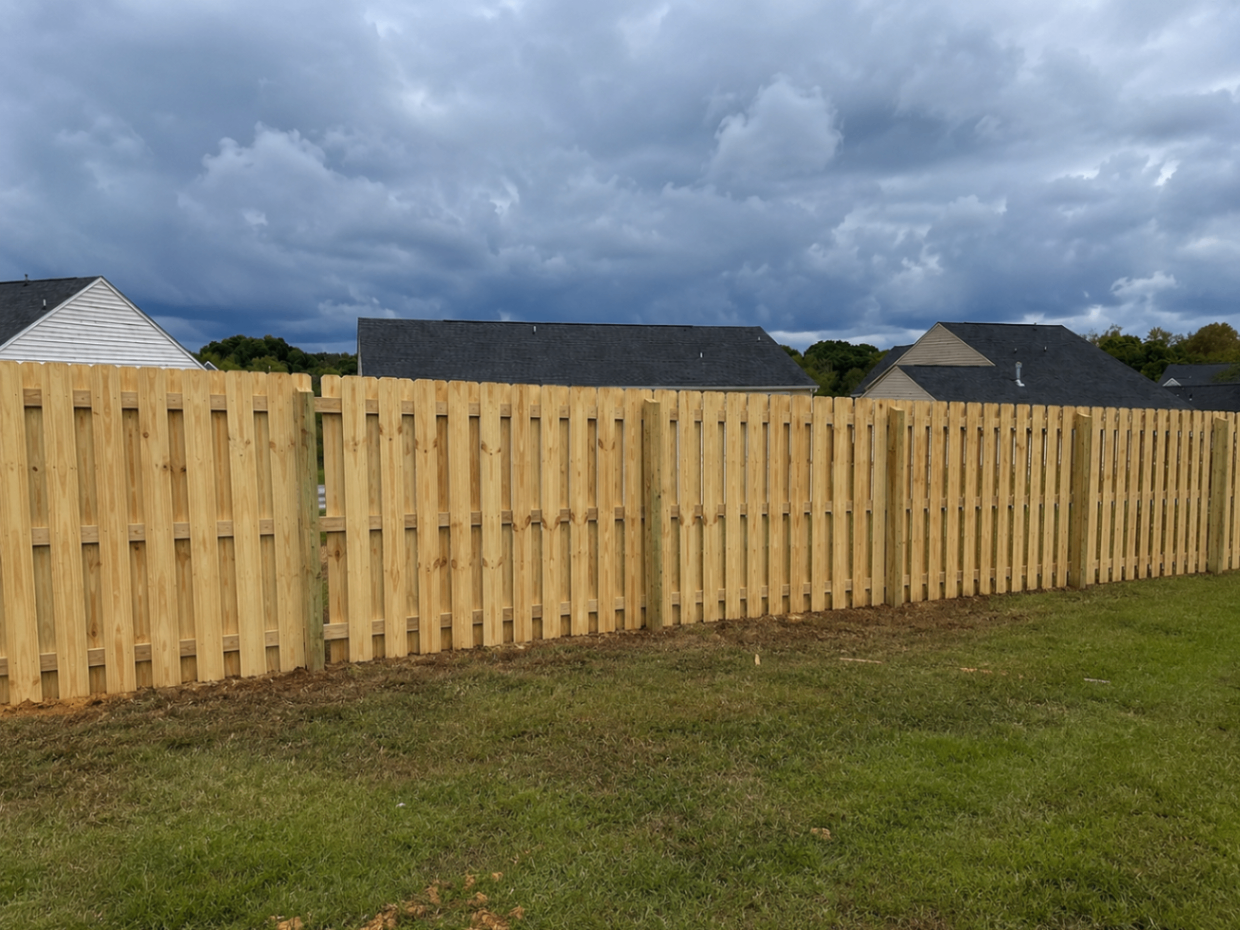 New wood privacy fence beneath dramatic sky