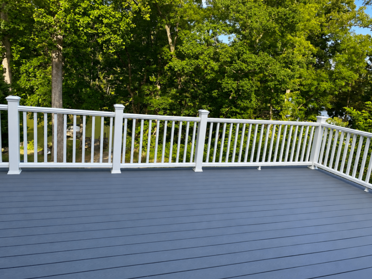Gray composite deck with bright white railing overlooking trees